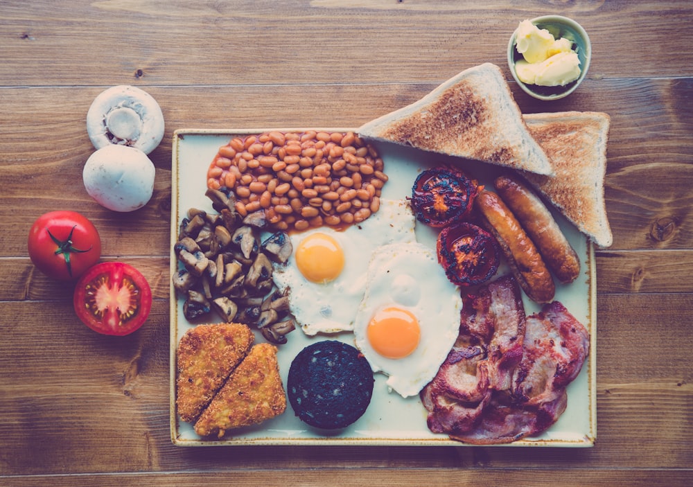 A classic cooked breakfast with eggs, bacon, beans and tomato