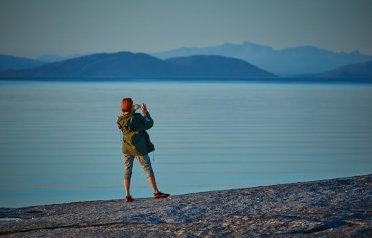 woman standing near body of water in Tranøy Norway