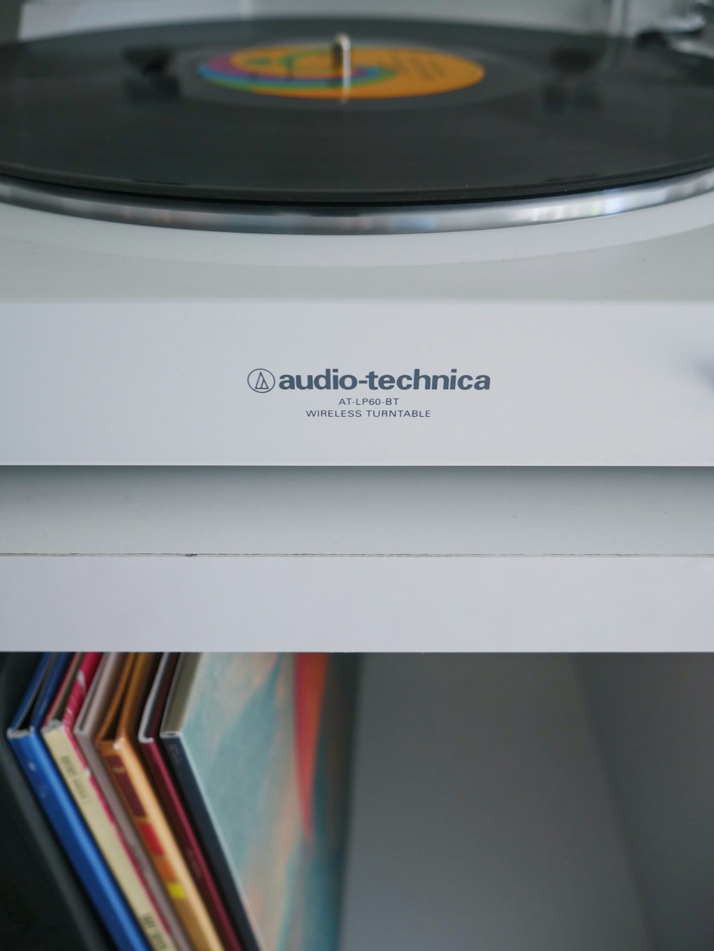 platine vinyle sans fil Audio-Technica blanche près de la pochette de disque vinyle