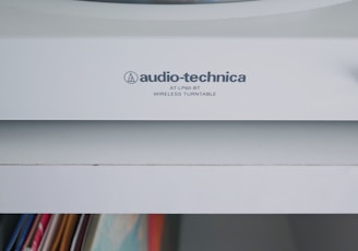 white Audio-Technica wireless turntable near vinyl record sleeve
