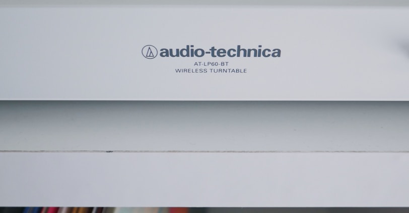 white Audio-Technica wireless turntable near vinyl record sleeve