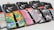 A row of colorful Nike Elite basketball socks with various graphic designs and packaging labels. The designs include bright patterns and abstract shapes, with each pair featuring a black line detail. The packaging is predominantly black with white and orange text.