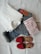 A set of clothing items are neatly arranged on a white background, including a folded white dress shirt, a pair of blue denim jeans with a visible Levi's label, a red and white striped shirt, and a pair of red open-toe sandals.