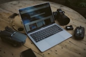 silver MacBook Air and SLR camera on table