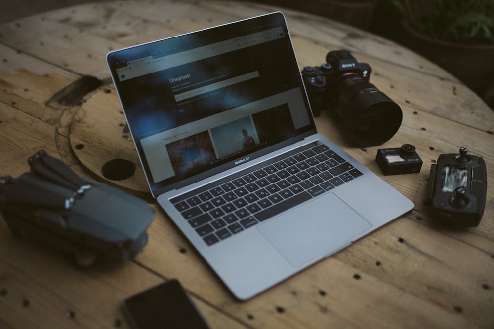 silver MacBook Air and SLR camera on table