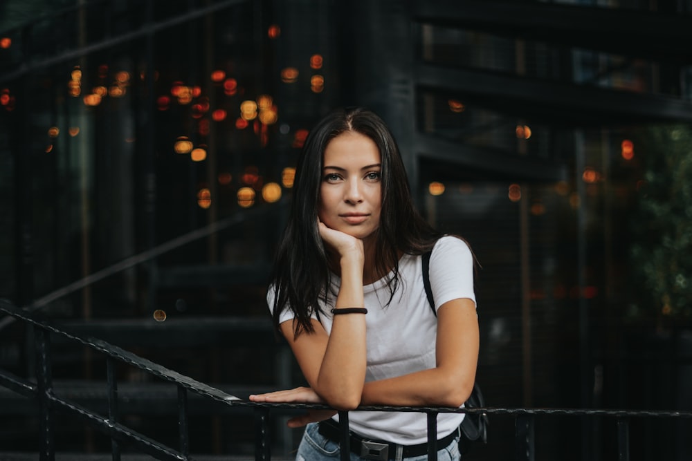 woman leaning on black handrail