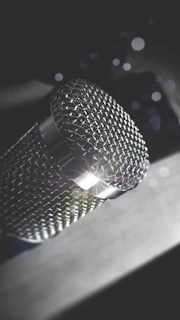 Close-up of a professional microphone with LED lights reflecting off metallic surfaces.