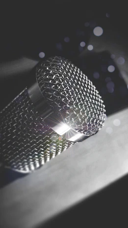 Close-up of a professional microphone with LED lights reflecting off metallic surfaces.
