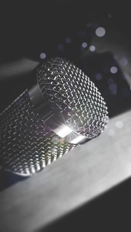Close-up of a microphone with a soft spotlight highlighting its metallic texture