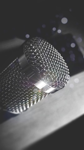 Close-up of a microphone with colorful glass effect reflections in a creative studio.