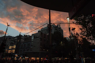 A vibrant behind-the-scenes shot of a film crew setting up lights on a busy city street at sunset