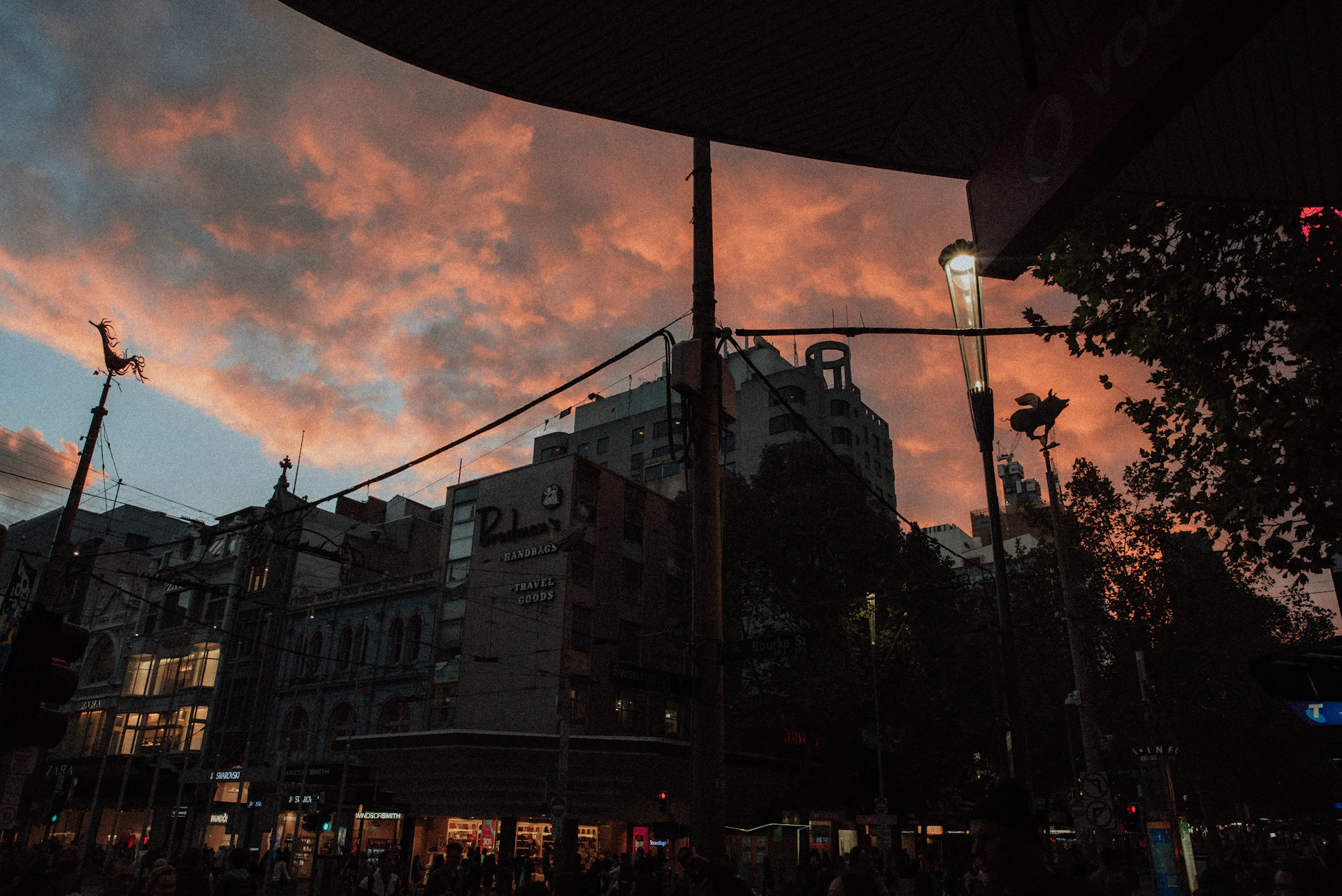 A street scene capturing the vibrant life of an urban neighborhood at sunset, with people interacting and colorful murals in the background.