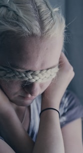 woman covering eyes using braided hair