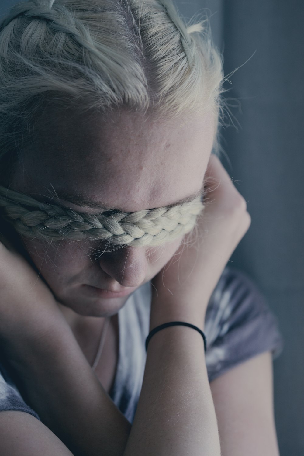 woman covering eyes using braided hair