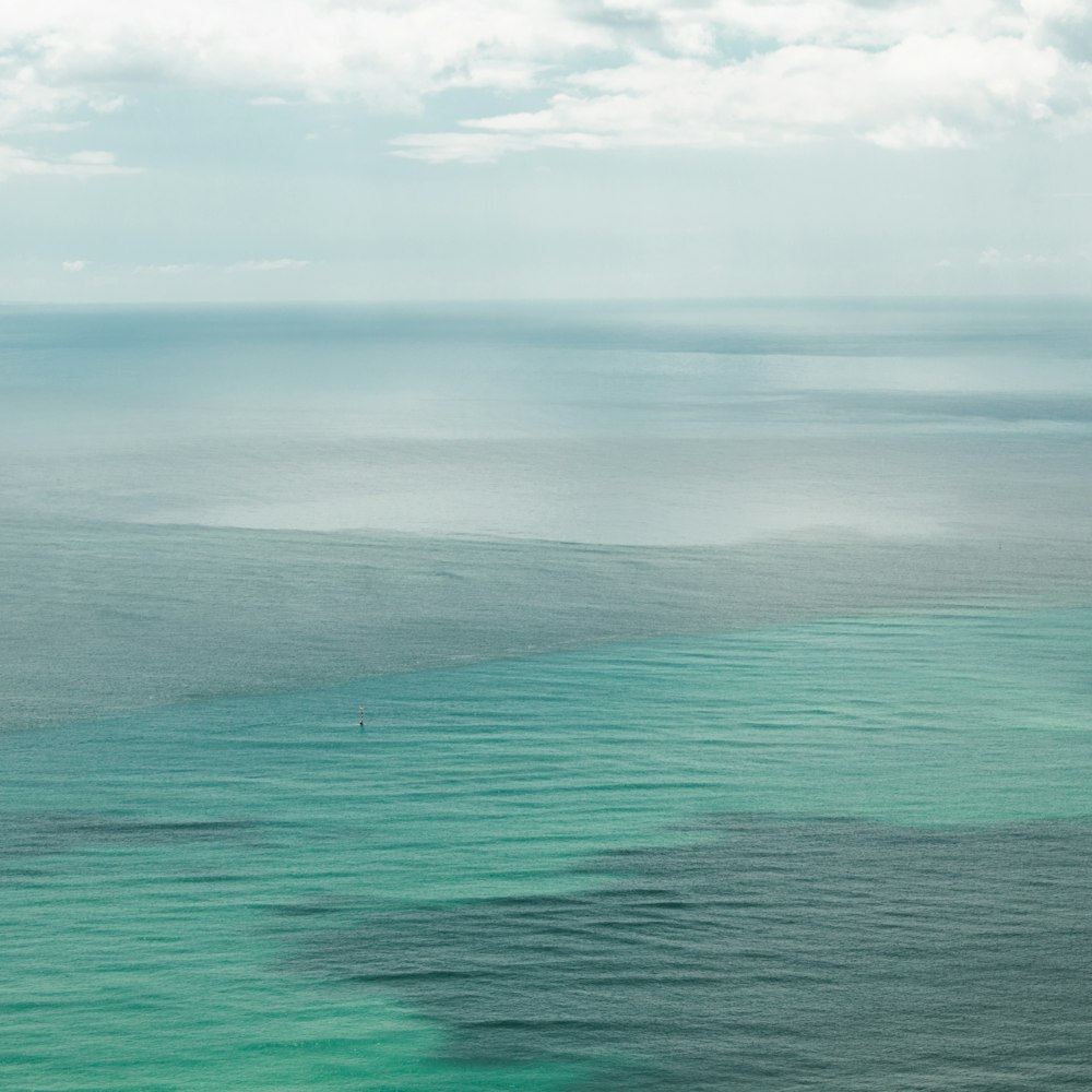 gray ocean water under white cloudy sky