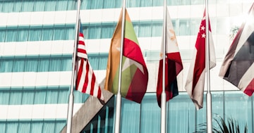 several country flags near to glass building