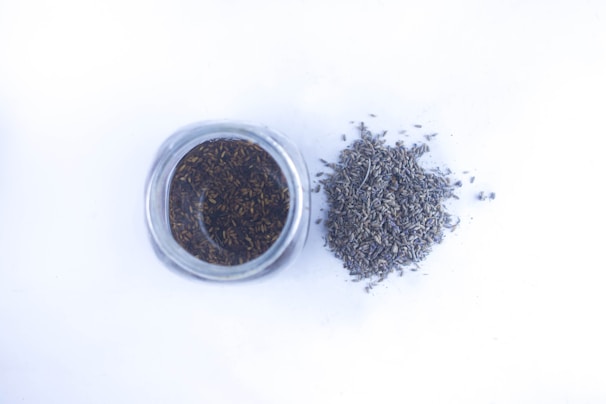 Dried lavender flowers scattered next to a candle wick.