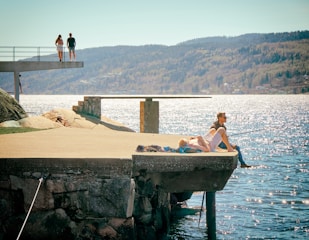 A serene lake with people fishing from accessible platforms.