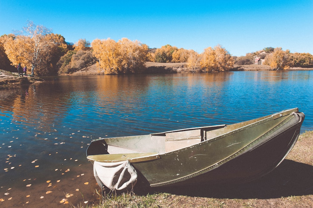 green canoe beside body of water