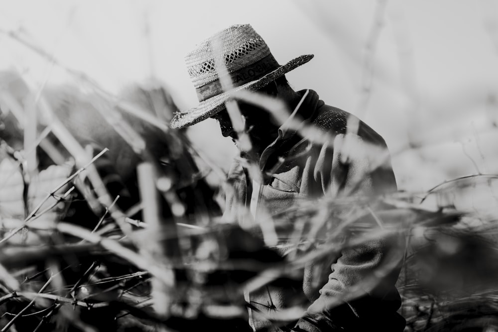 Graustufenfotografie eines Mannes mit Hut