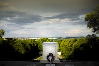 A solemn memorial ceremony with veterans paying respects at a monument.