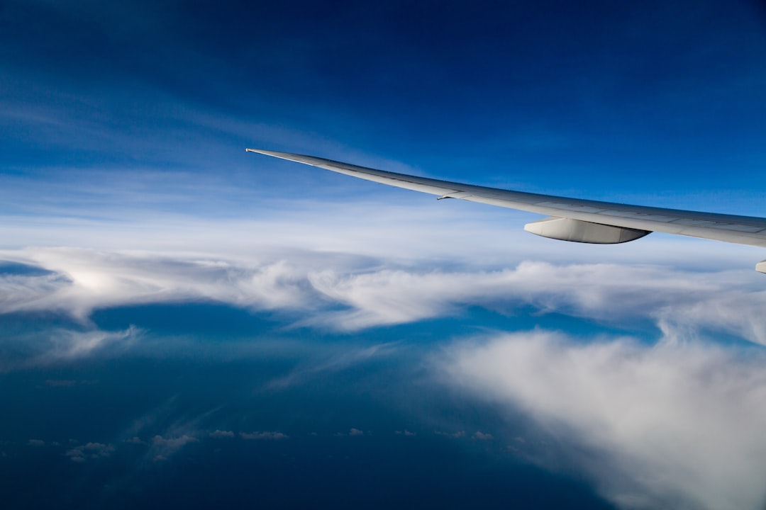 plane over white and blue clouds, A flight to paradise island