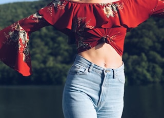 woman standing near body of water while closing her eyes