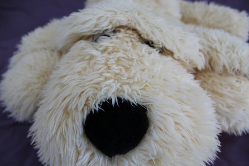 Close-up of a soft, eco-friendly plush toy prototype with natural cotton fabric and delicate stitching.