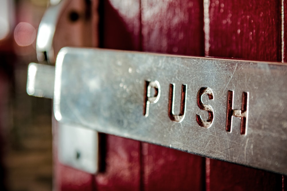 a close up of a metal sign on a red door