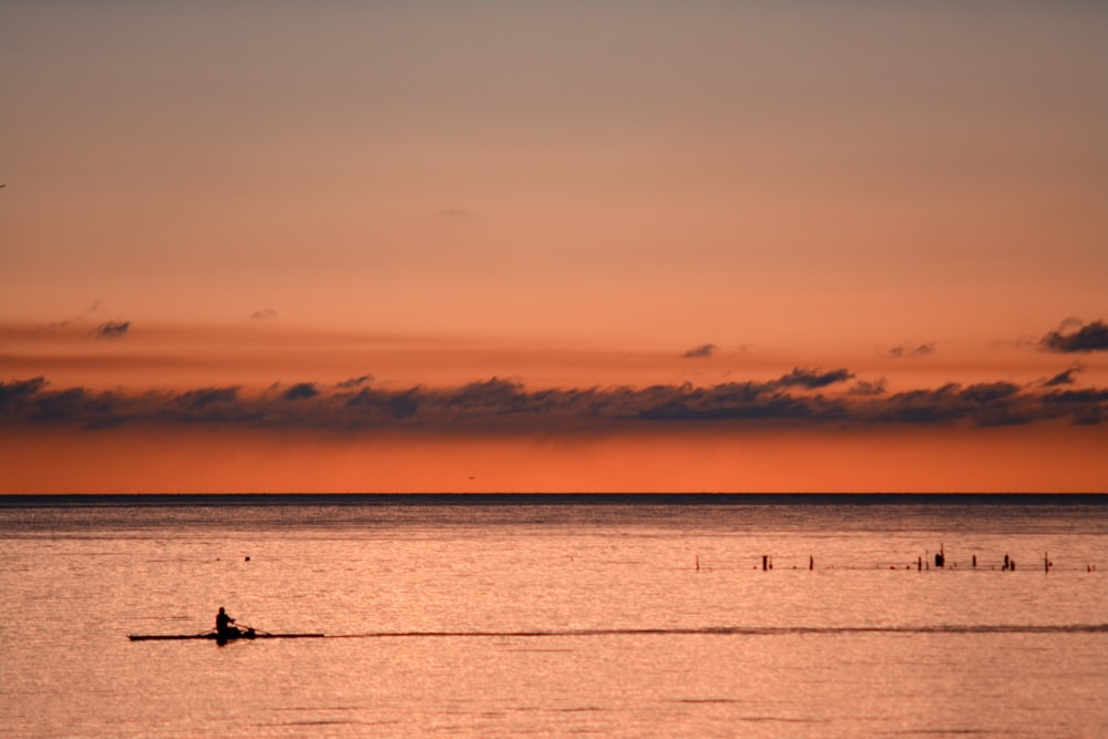Persona navegando en kayak durante la puesta de sol