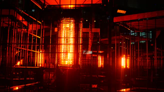 A glowing thermal energy storage unit layered with solid media, radiating warmth in a high-tech industrial setting.