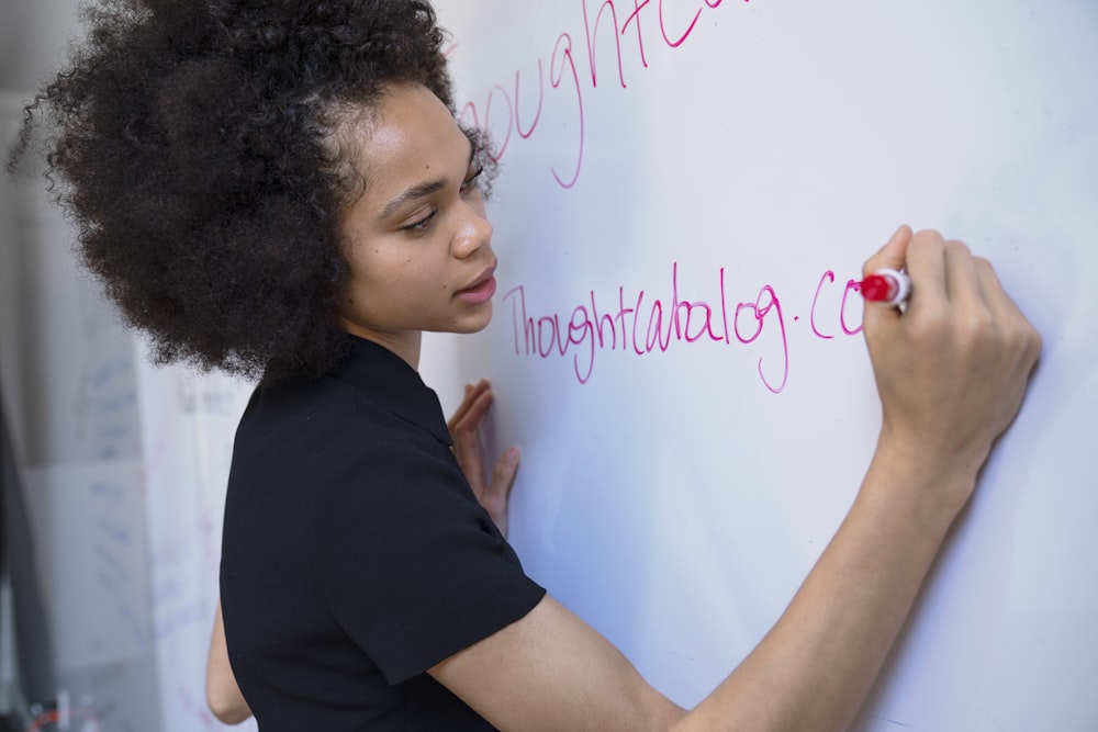 woman writing on dry erase board