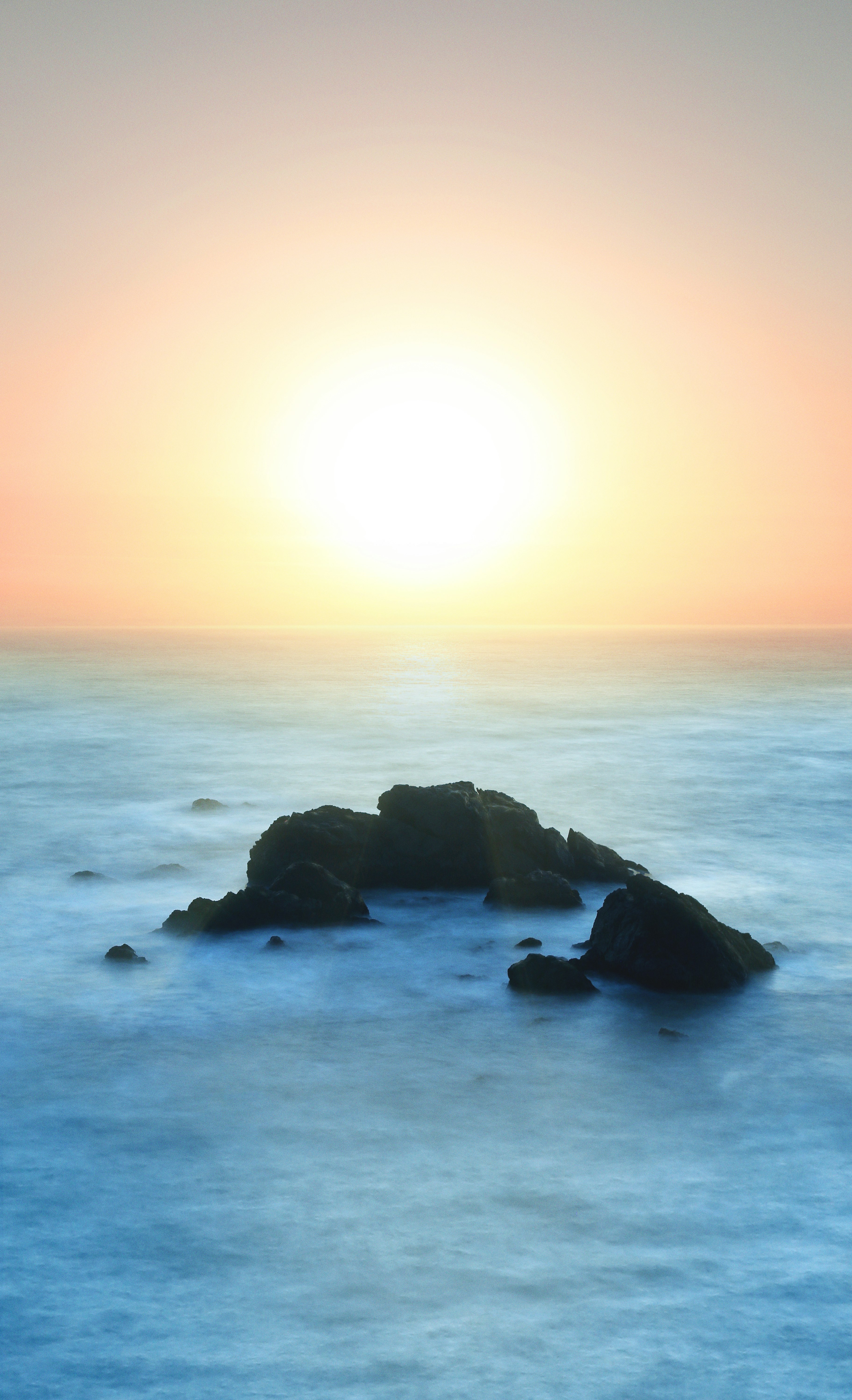 black rock formation at middle of sea