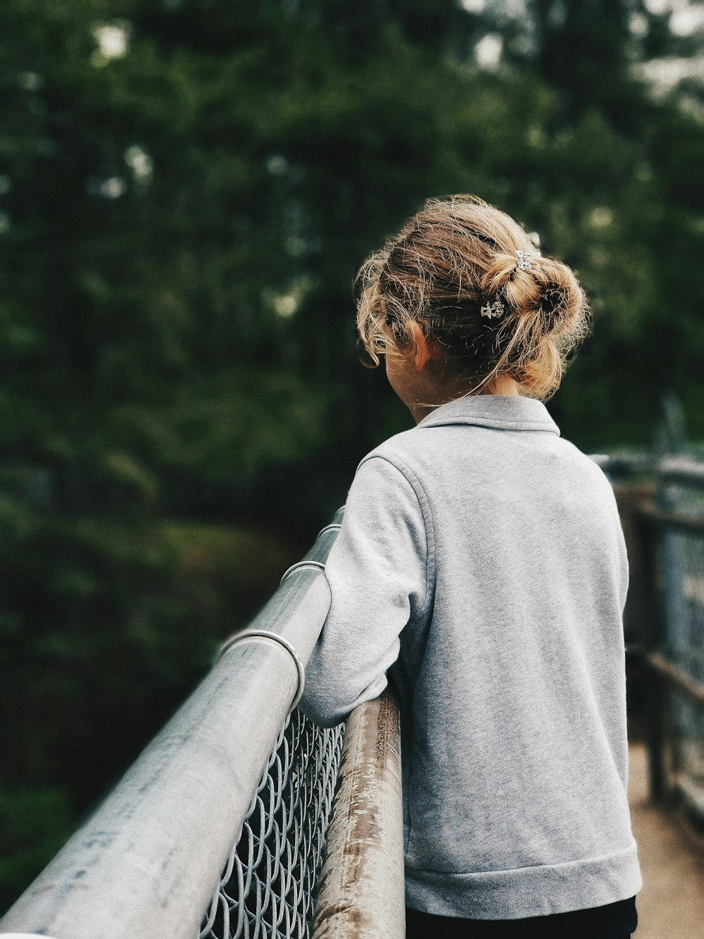 girl standing near gray metal fence