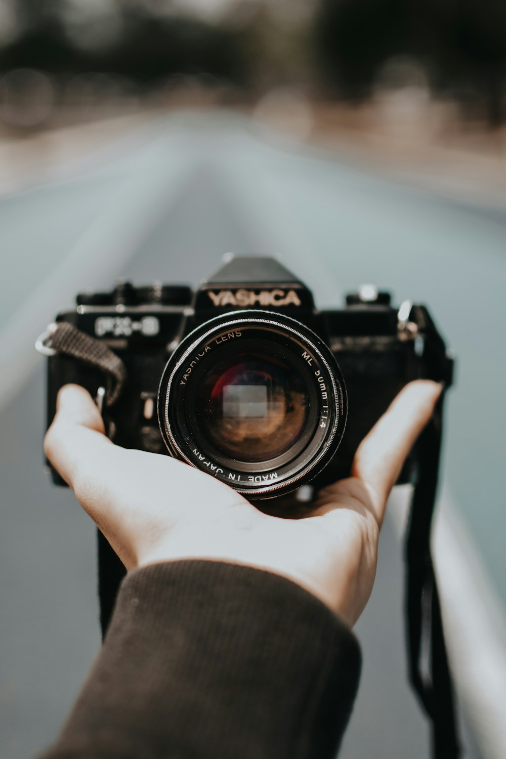 person holding black Yashica camera