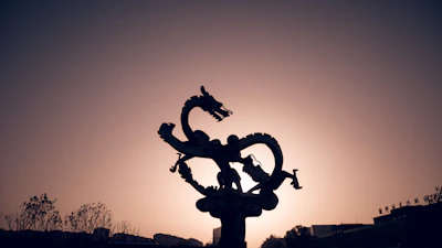Sketch of a fierce dragon soaring over a medieval castle at dusk.