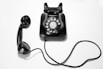 black rotary dial phone on white surface