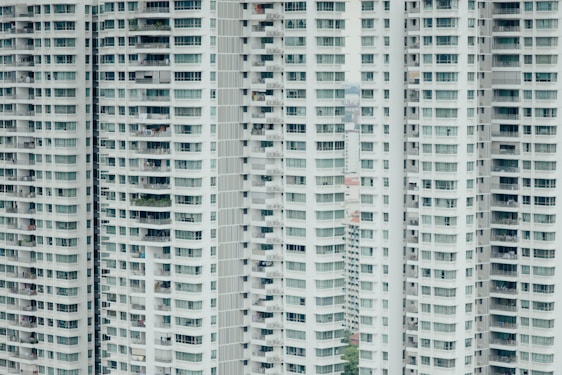 Tall residential buildings with numerous balconies and windows stacked vertically. The structure is repetitive, with each floor mirroring the one below and above, creating a uniform pattern.