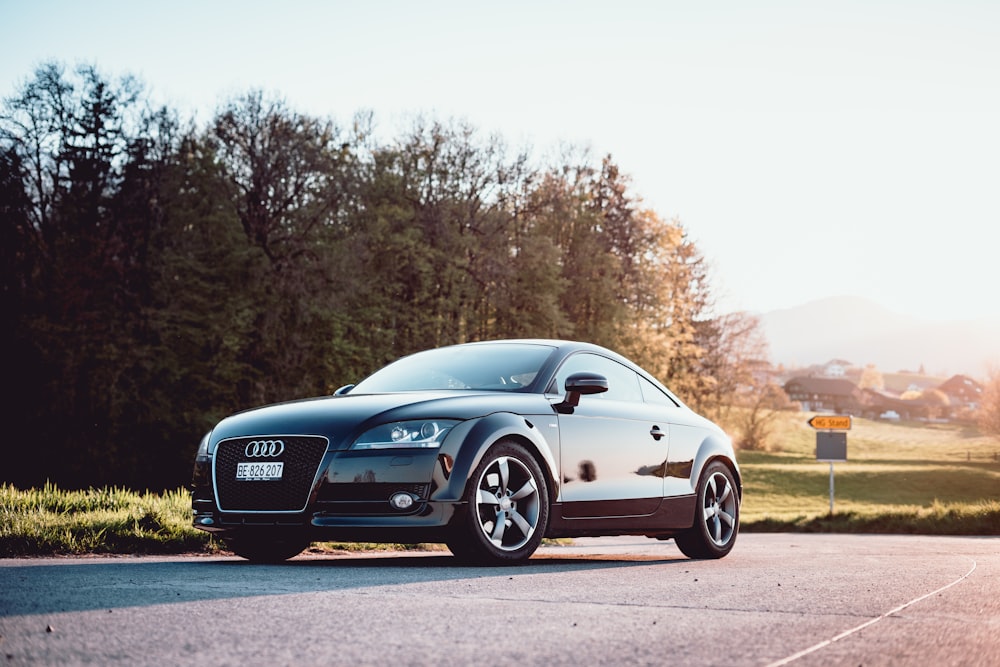 black Audi coupe parked on gray concrete road