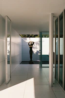 A bright hallway decorated with framed art prints and a sleek modern sculpture on a minimalist console.