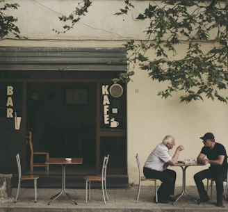 two man chatting white sitting on brown wooden chair
