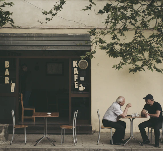 two man chatting white sitting on brown wooden chair