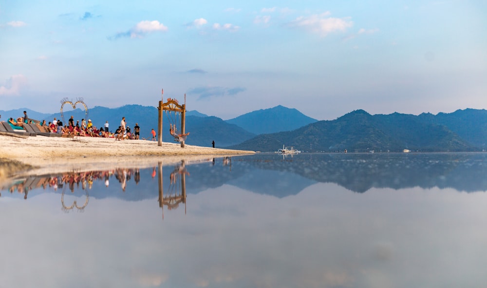 people gathering on shore under cloudy sky