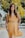 woman wearing orange sleeveless dress standing near yellow flower tree