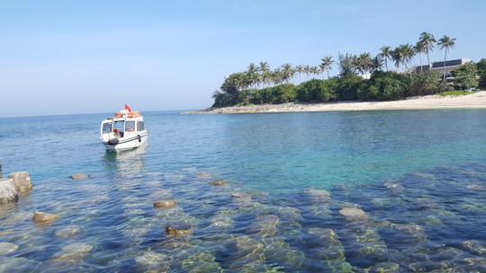 A sleek motorboat cruising along the turquoise waters near Mallorca’s coastline under a clear blue sky.
