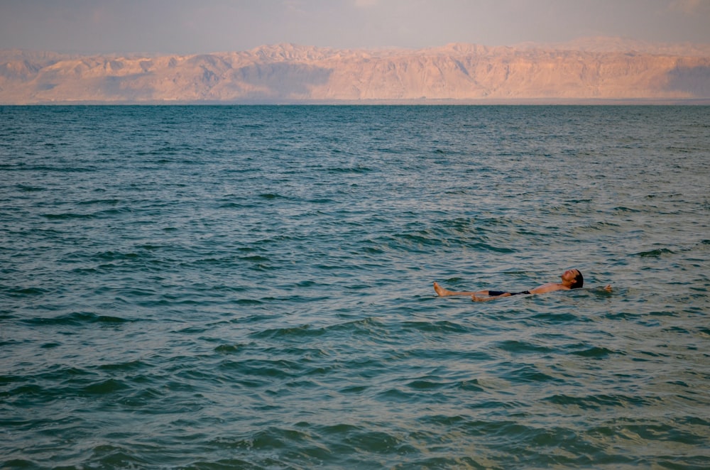 a person swimming in the middle of the ocean