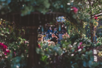A group of members enjoying a sunny afternoon in the community garden area surrounded by lush greenery.
