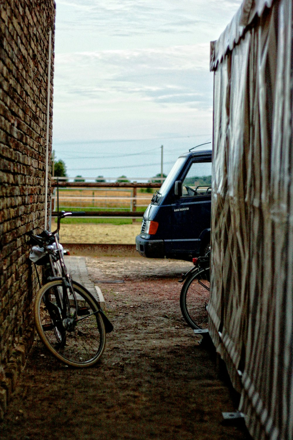 black bicycle leaning on brown wall