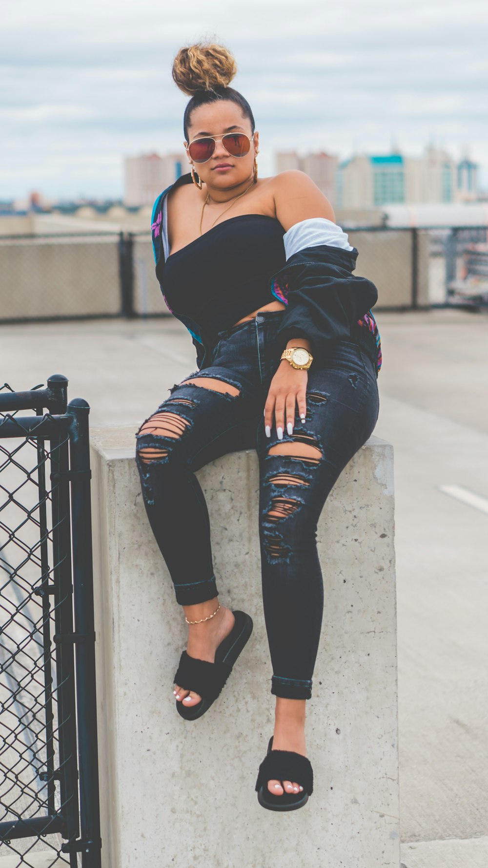 woman sitting on gray concrete pillar