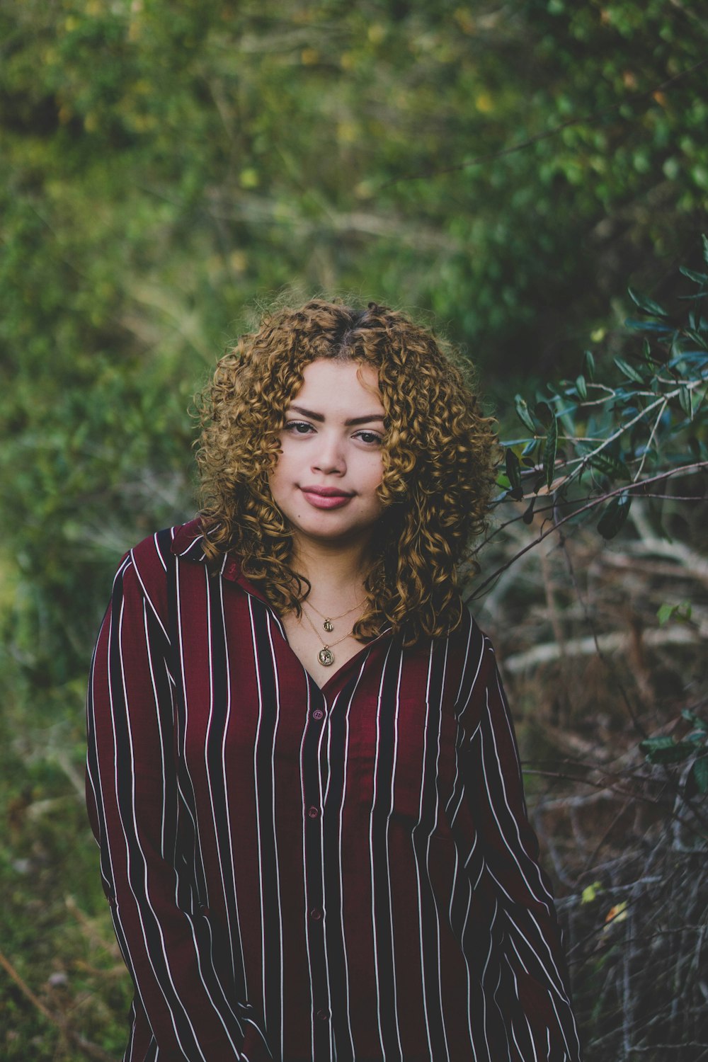 woman standing beside green leaf plants selective focus photography